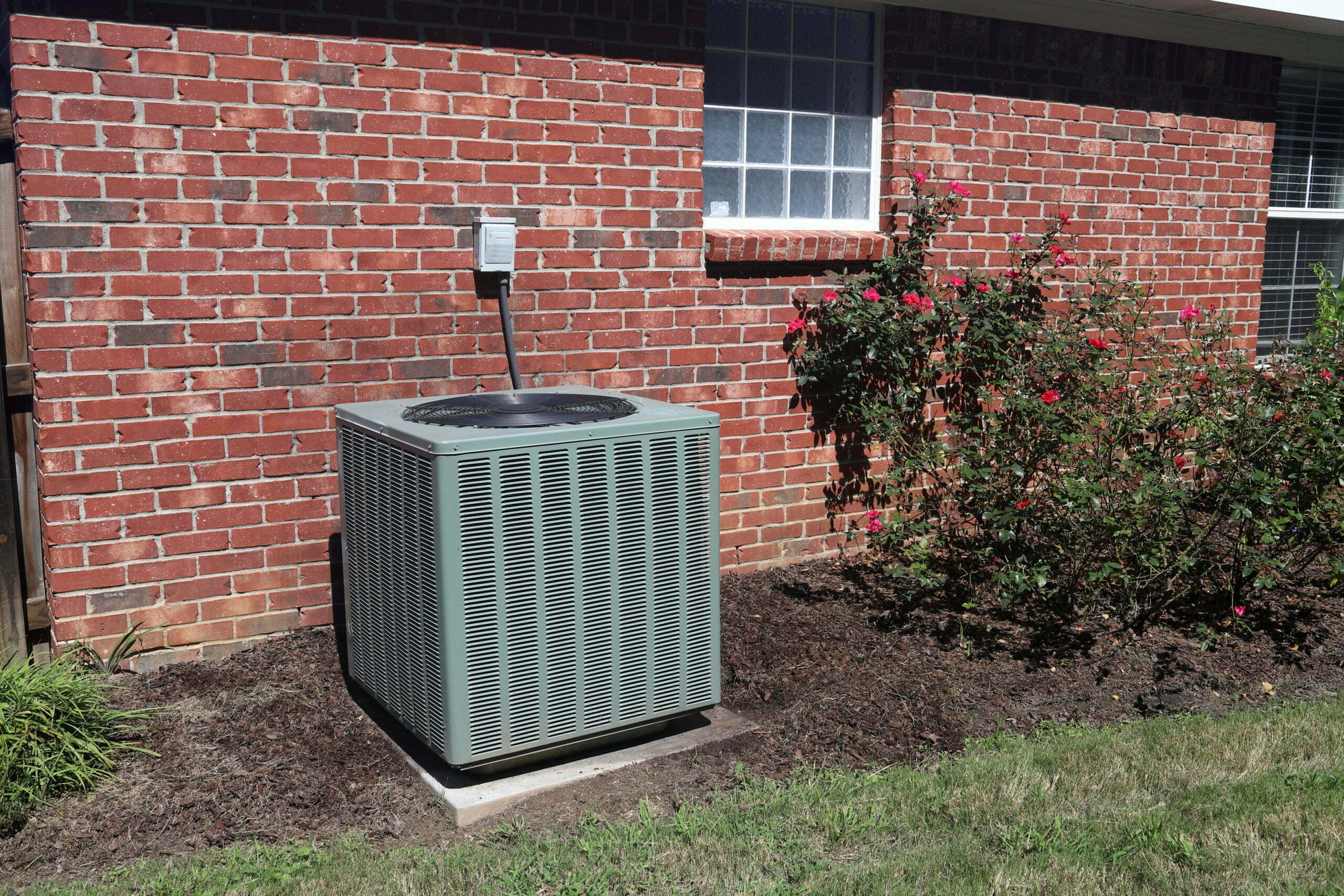 a grey trash can outside of a brick building